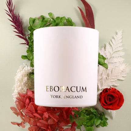White candle with 'Eboracum York, England' text surrounded by flowers on a light background